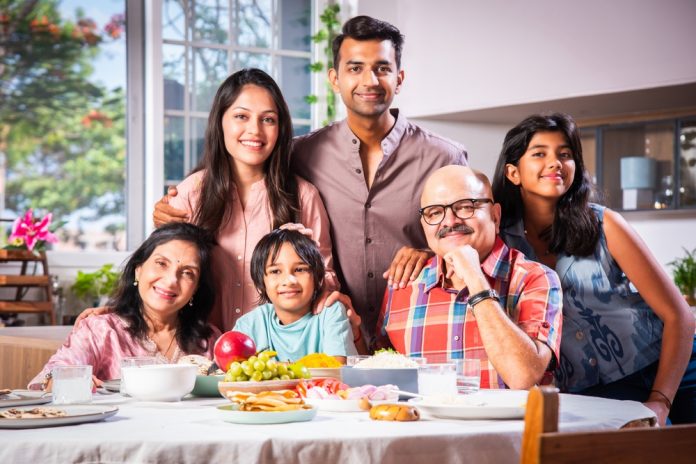 Portrait,Of,Indian,Family,Of,Three,Generations,Eating,Meals,Together