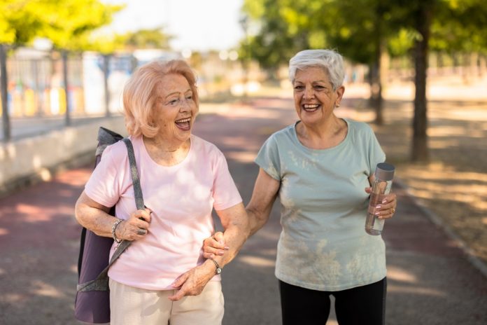 Two,Happy,Elderly,Women,Are,Walking,Together,In,A,Park
